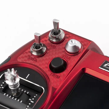Close-up of Flysky Elysium EL18 RC transmitter showing switches and controls on red surface.